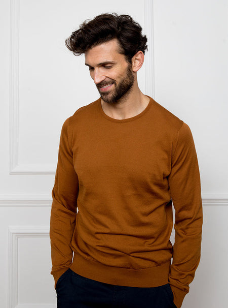 Man wearing ginger/burnt orange crewneck sweater knit in 100% luxury and premium merino wool.